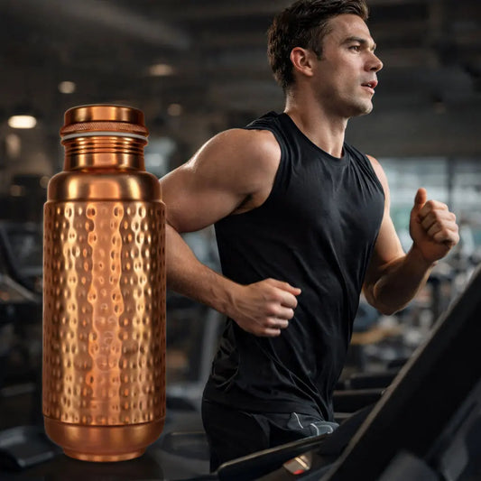 Man running on a treadmill with a Atomic29 Jumbo copper water bottle next to him