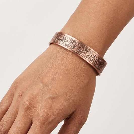 Copper Celtic tree bracelet on a wrist with a plain background
