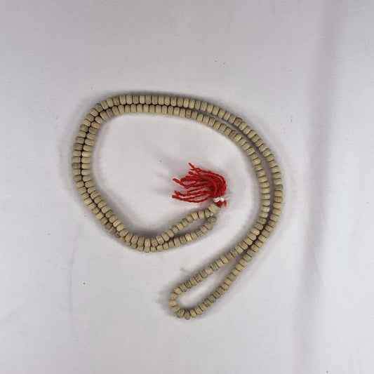 String of tulsi (holy Basil) beads with a red tassel on a white background
