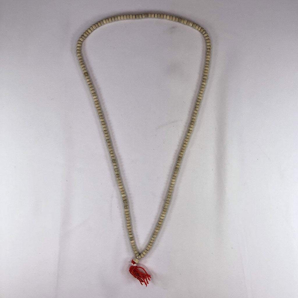 tulsi (holy basil) Necklace with a red tassel on a white background