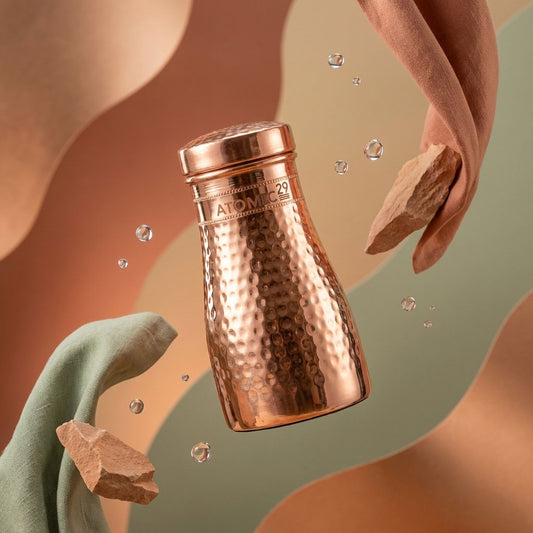 Copper bottle with 'Atomic' branding on a abstract background