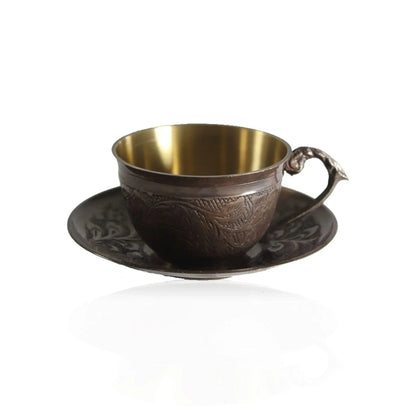Bronze cup with brass interior on a matching saucer against a white background