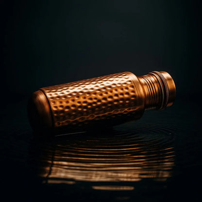 Copper water bottle with Hammered textured surface on a black background