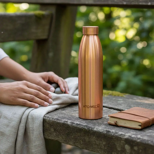 Copper bottle on a wooden surface with a blurred natural background