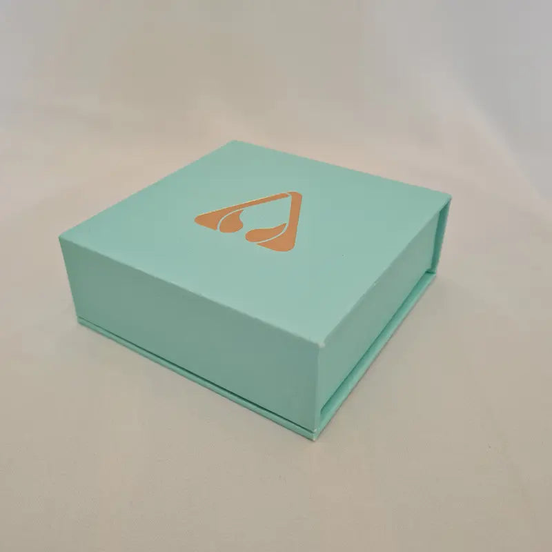 atomic29 turquoise blue bracelet gift box with a gold logo on a light grey background