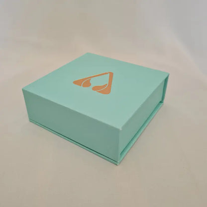 atomic29 turquoise blue bracelet gift box with a gold logo on a light grey background