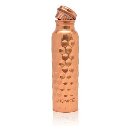 Copper water bottle with honeycomb design on a white background
