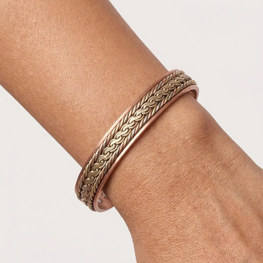 Brass braided copper bracelet on a wrist against a light background