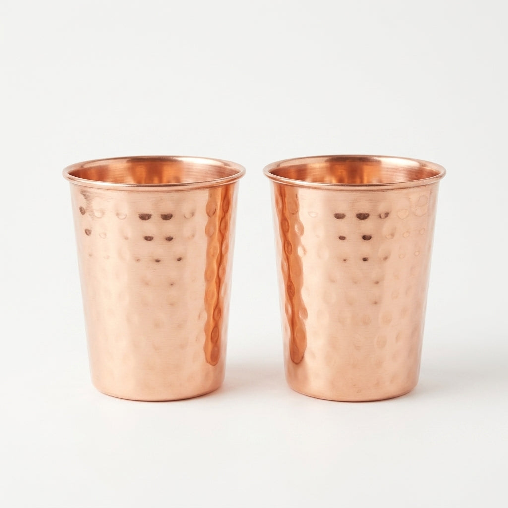 Two copper tumblers with a hammered texture on a white background