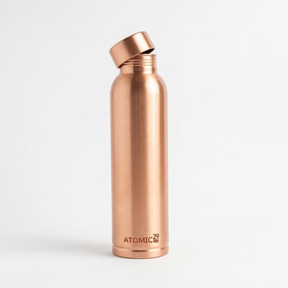 A copper water bottle with a matching cap, shown on a clean white background. The brand name 'ATOMIC2' is printed near the bottom.