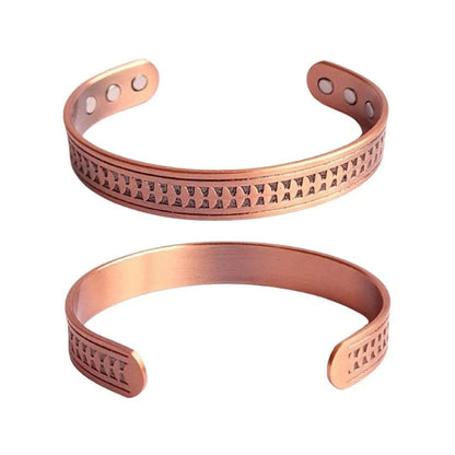 Two copper bracelets with engraved patterns on a white background