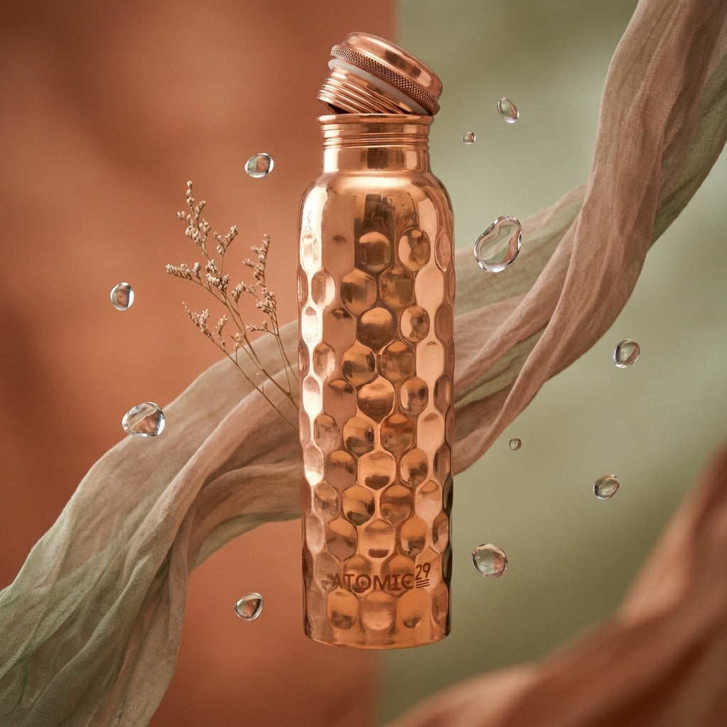 diamond copper water bottle with open lid floating with water drops around it 