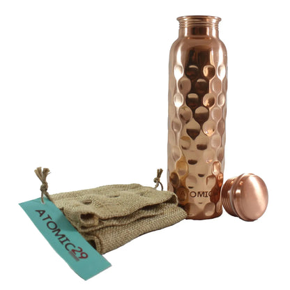 Copper water bottle with textured design, burlap pouch, and 'Atomic29' tag on a white background