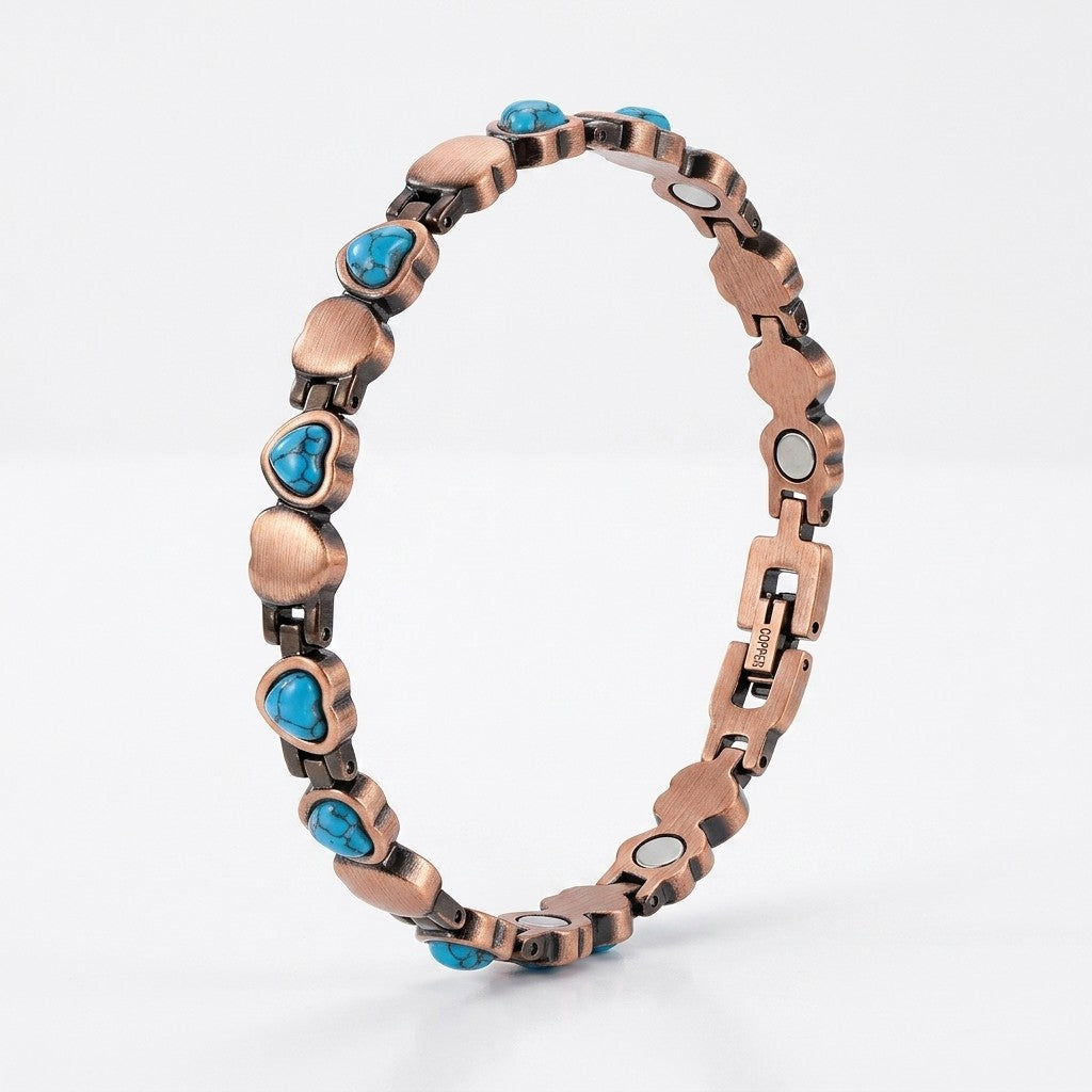 A heart-link copper magnetic therapy bracelet, accented with small heart shaped turquoise blue stones, shown on a light grey background.
