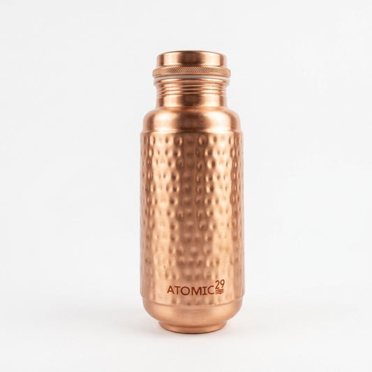 A  JUMBO copper water bottle with a hammered texture and a ribbed screw cap, featuring the brand name 'ATOMIC29' printed near the bottom, set against a plain white background.