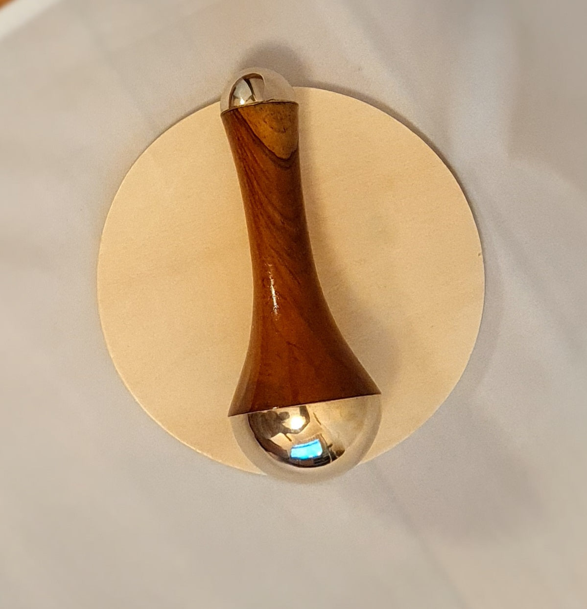 kansa massage wand place on wooden circular block