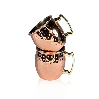 Two stacked copper shot mugs with gold handles on a white background