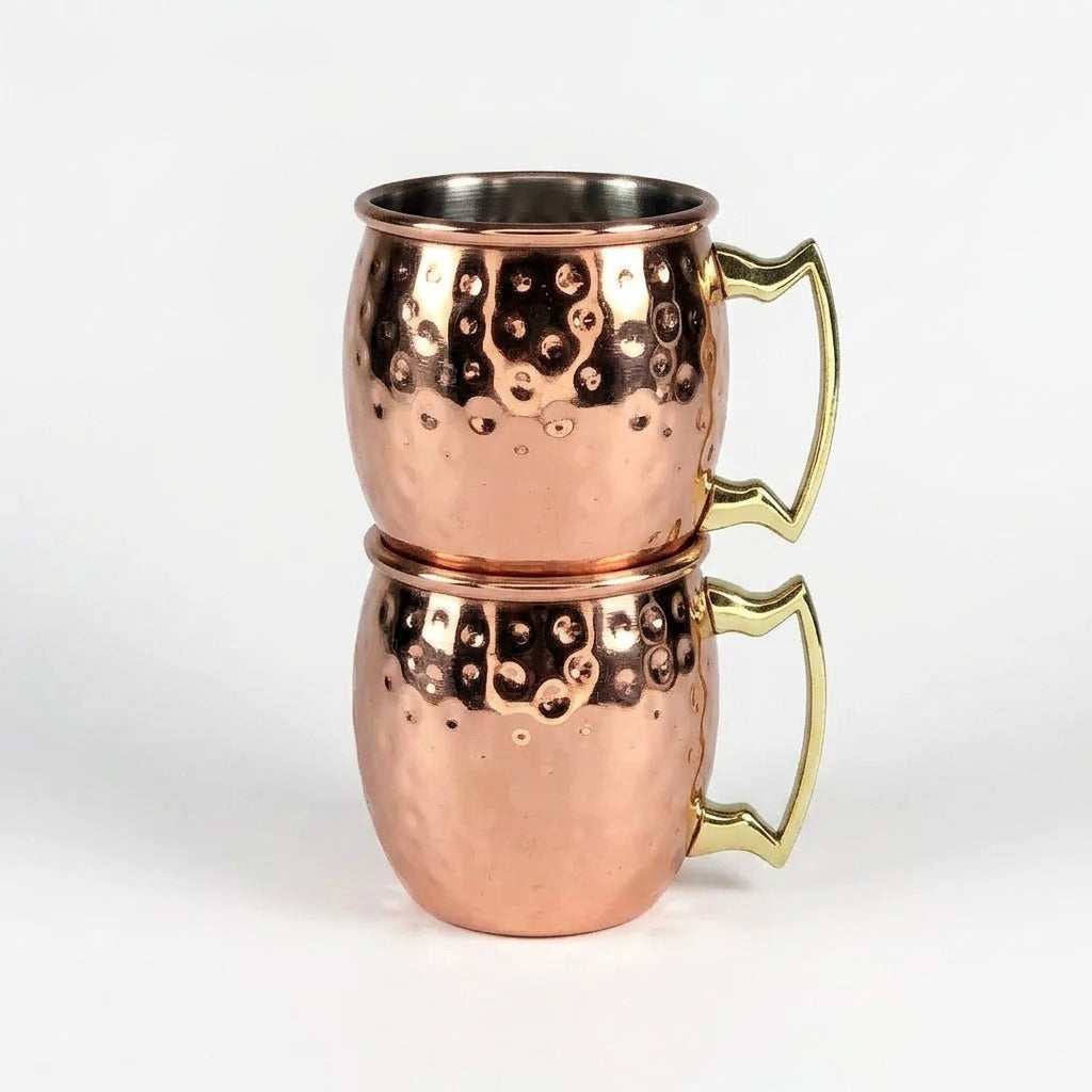 Two copper mugs with brass handles on a white background