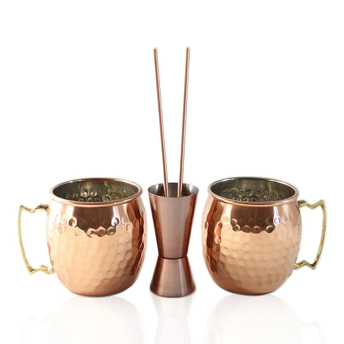 Set of two copper mugs, straws and a jigger on a white background
