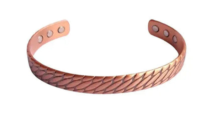 Copper bracelet with embossed scale design on a white background