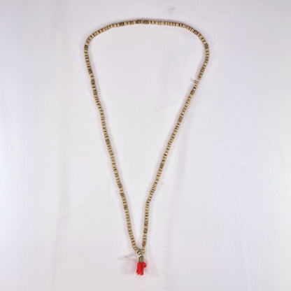 Necklace with tulsi (holy basil) beads and a red tassel on a white background